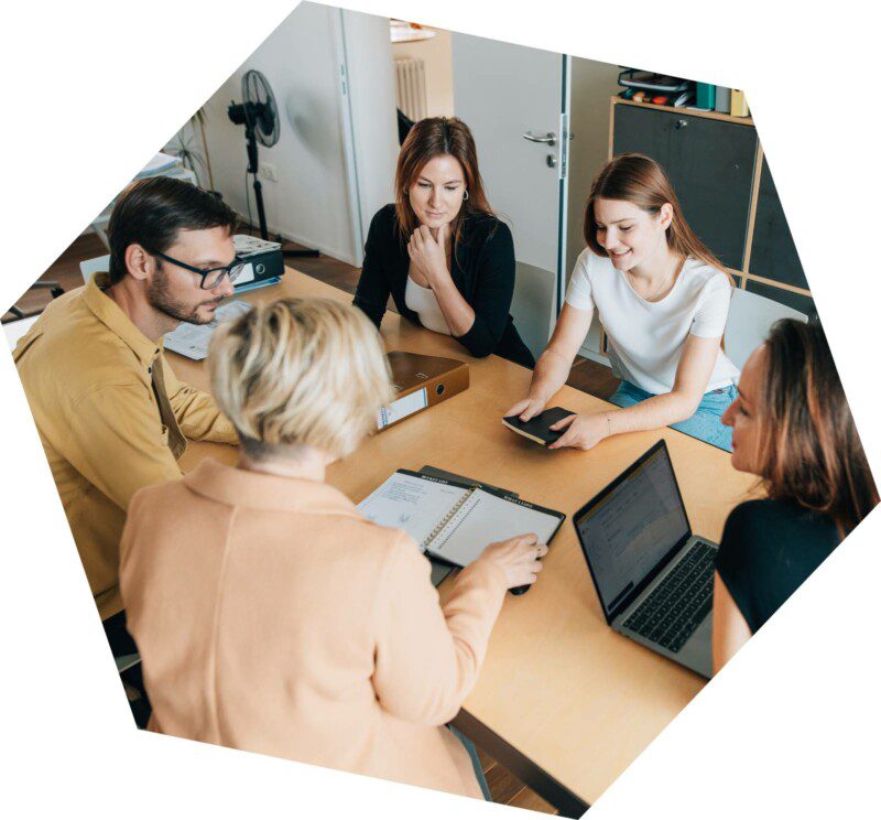 Skupina lidí diskutující u stolu o strategiích UGC marketingu.