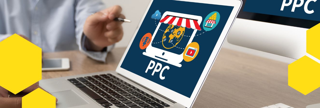 Laptop s grafickým zobrazením PPC kampaně a rukou ukazující na obrazovku.