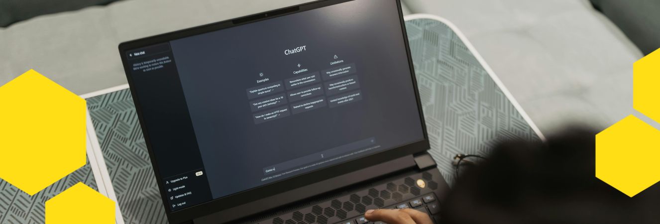 Obrázek zobrazuje osobu pracující na laptopu, kde je otevřený ChatGPT s ukázkami příkazů a příklady textu. Na obrazovce je vidět rozhraní pro zadávání požadavků a výběr příkladů použití. V levém dolním rohu je logo Včeliště v žluté barvě.